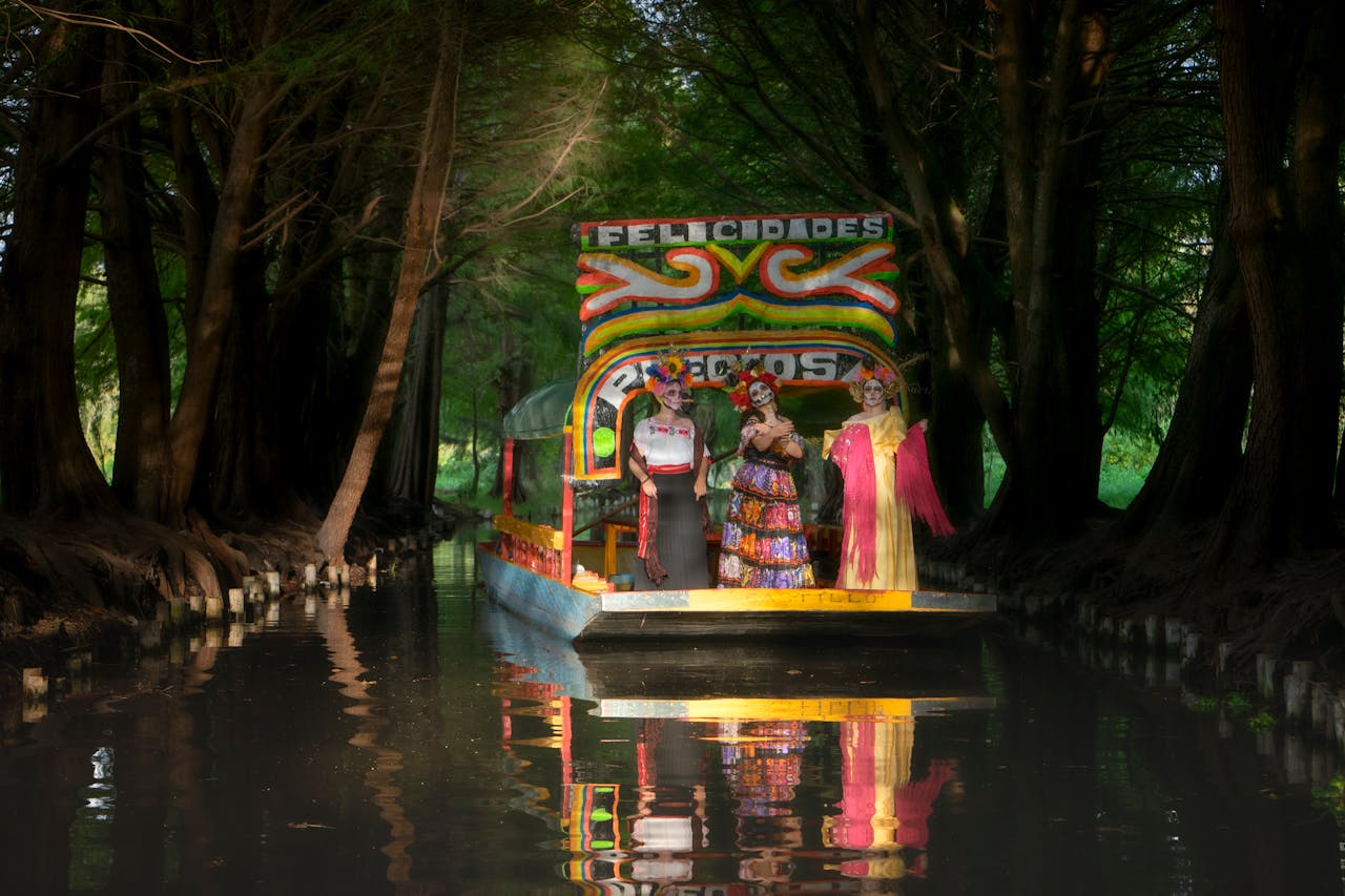 A vibrant barge with people in festive costumes on a scenic canal, celebrating Day of the Dead.